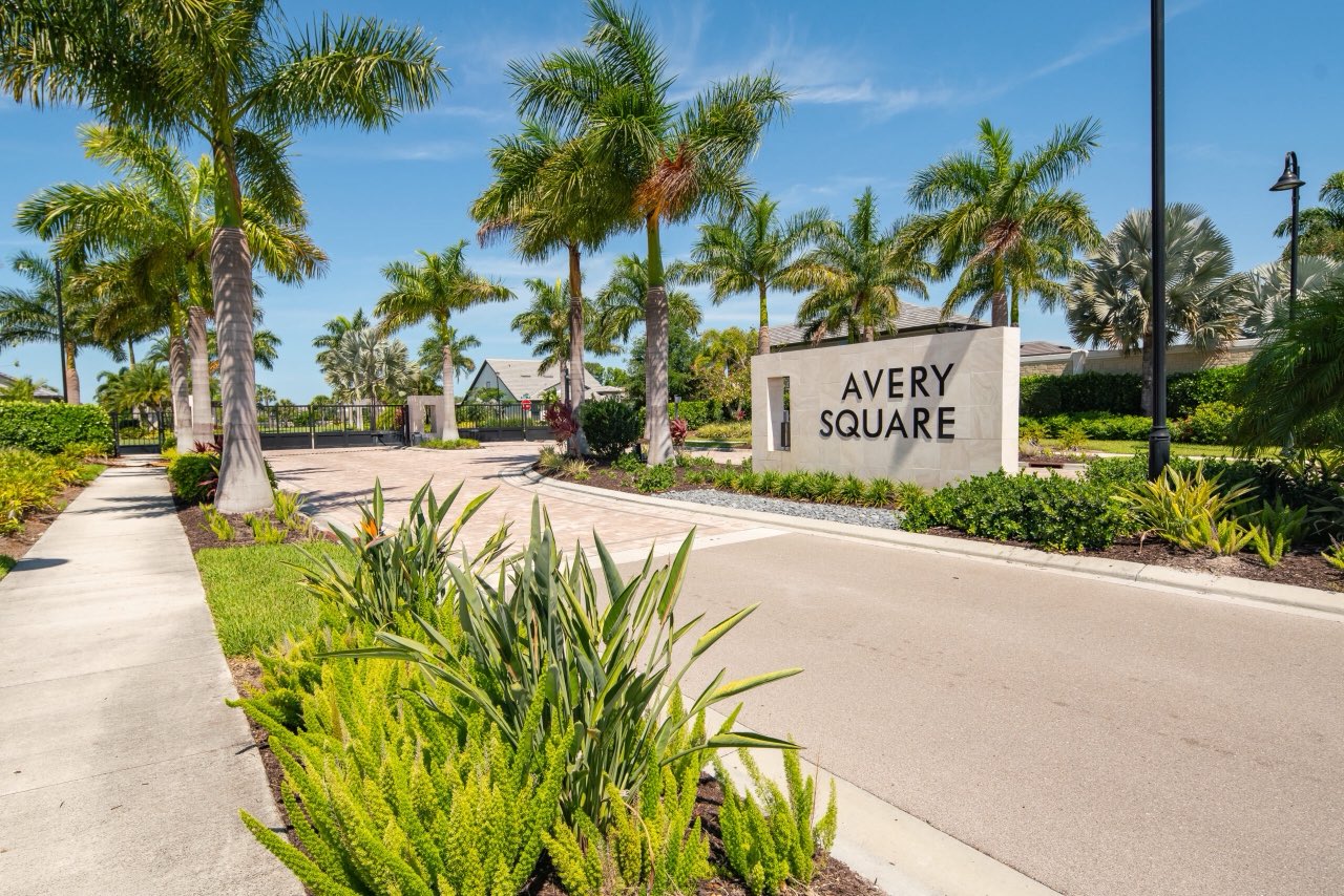The Avery Square sign and gated entrance, lined with royal palms