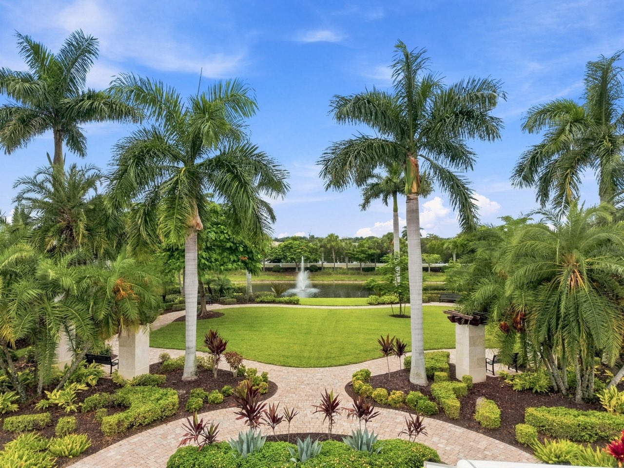 Aerial view of the park lawn and palms leading to the lake fountain